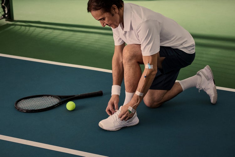 Tennis player tying his shoe