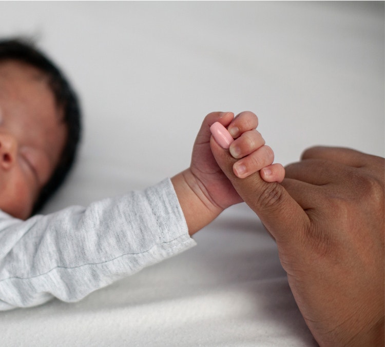 Main de bébé autour d’un doigt