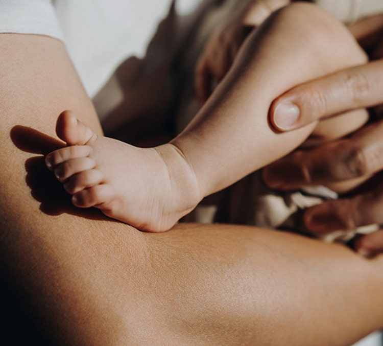 Pied de bébé sur bras